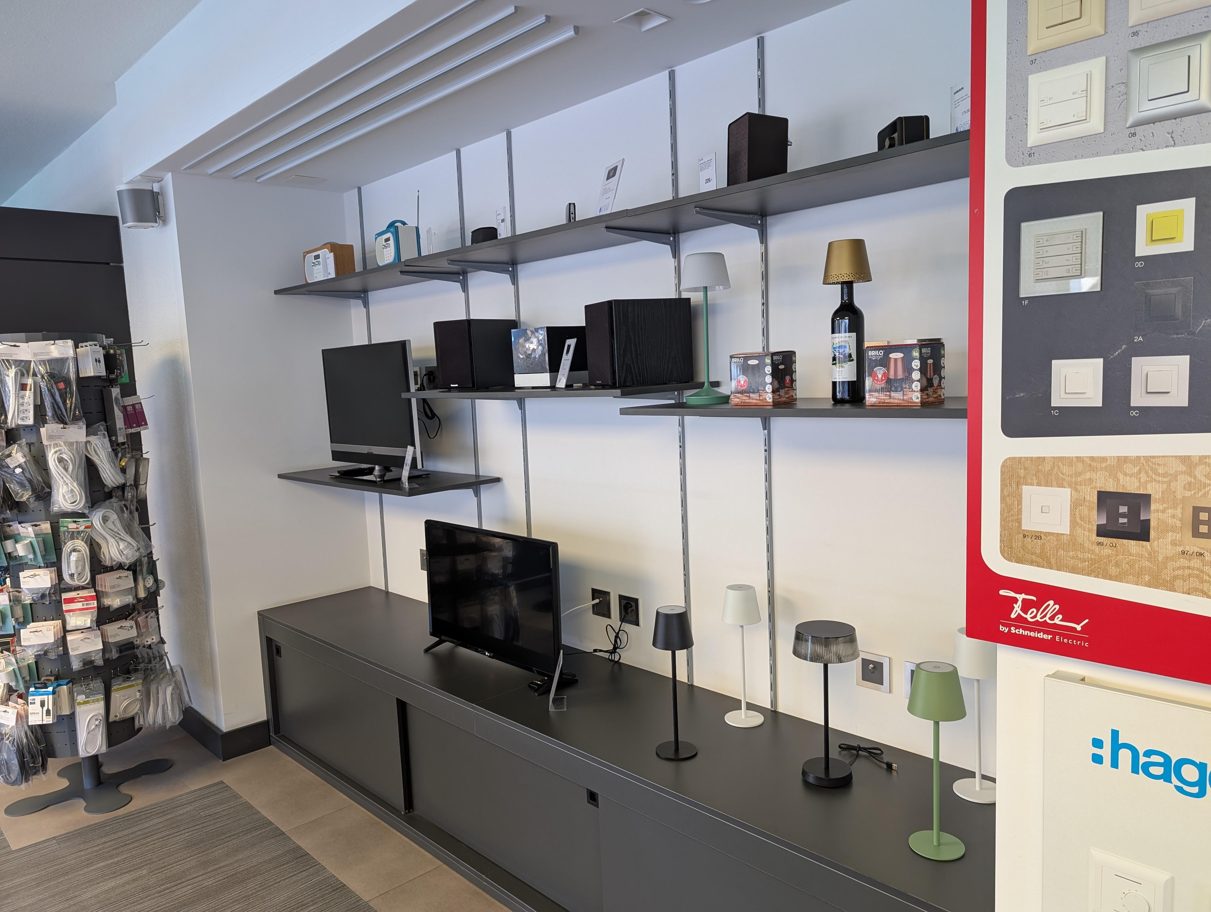 Conseiller en électroménager présentant un appareil Miele à un client dans le showroom chaleureux d'AlpInnovate SA à Matigny-Croix, Valais