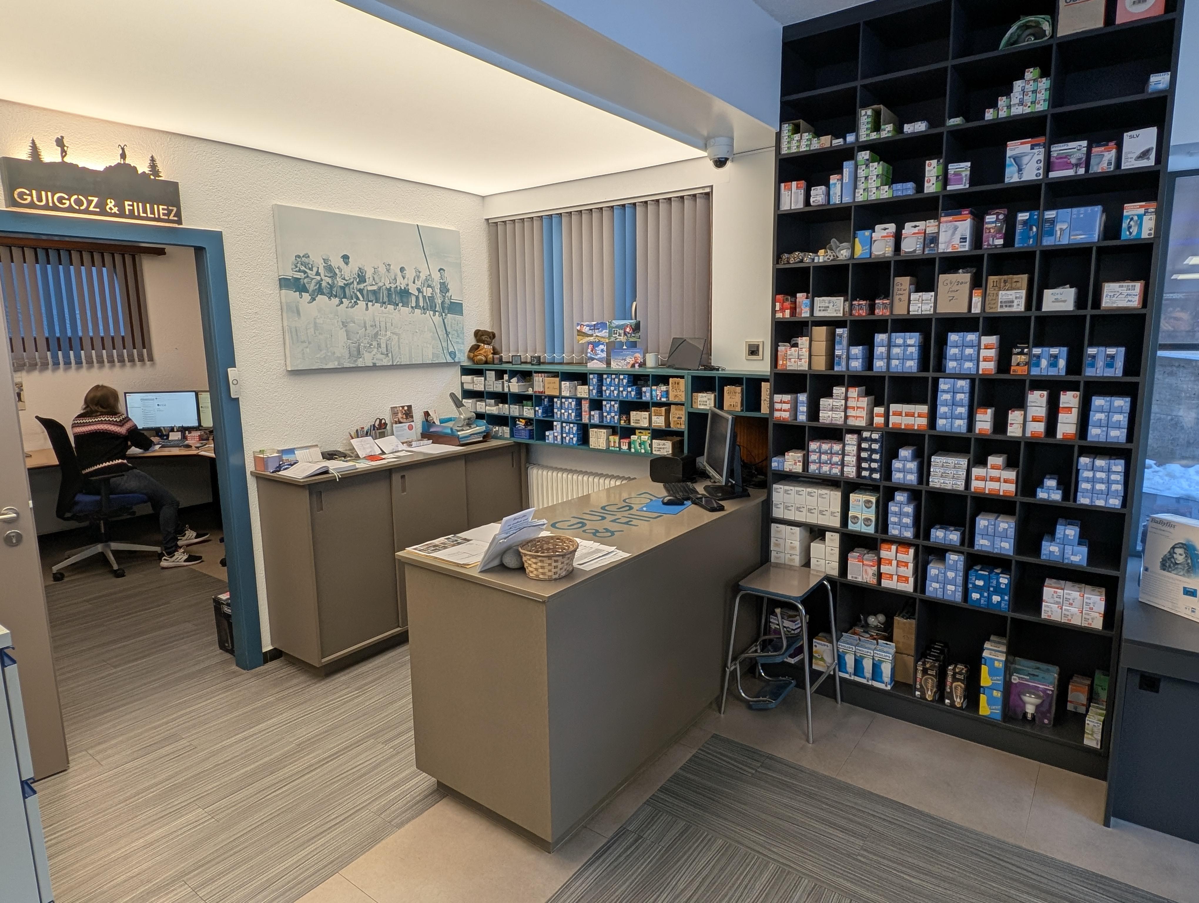 Showroom chaleureux d'électroménager haut de gamme avec des appareils Miele et Nespresso exposés sous un éclairage soigné, ambiance atelier valaisan aux tons ardoise et laiton